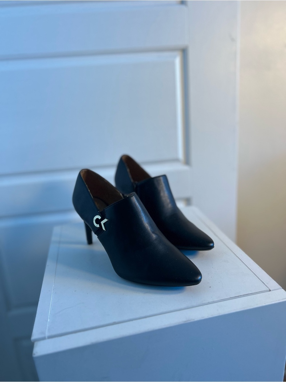 Calvin Klein black pointed-toe heeled booties with a sleek minimalist silhouette